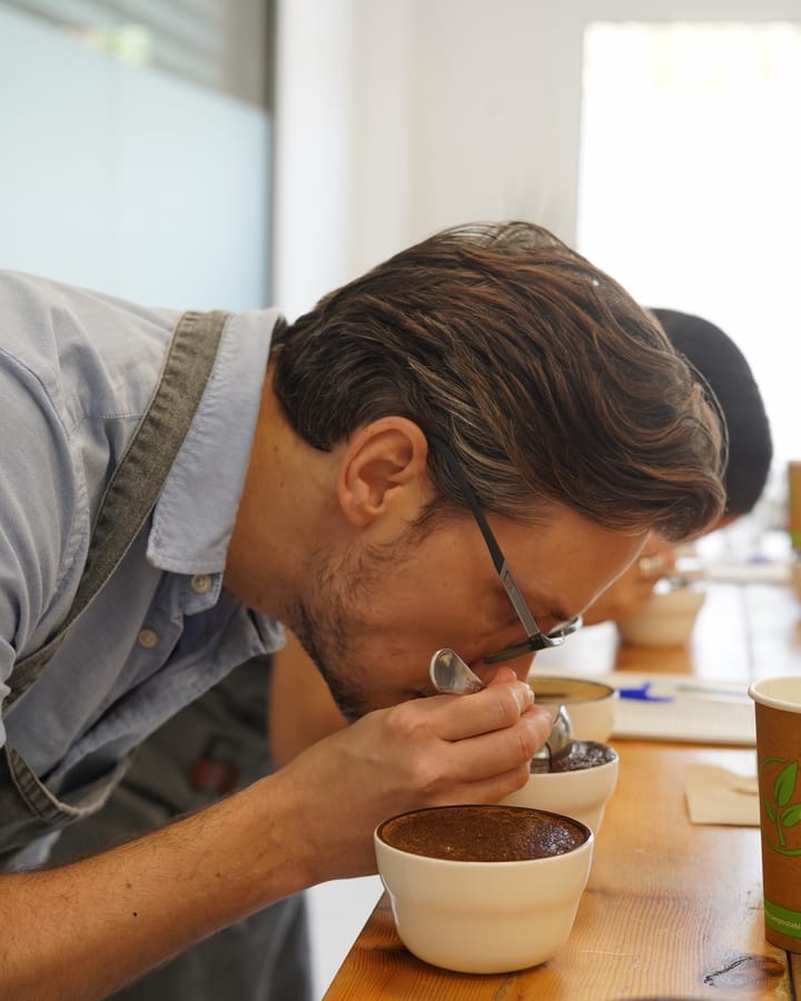 Kaffe provsmakas med sked vid en provning